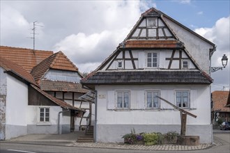 Old fountain in front of a half-timbered house, Hunspach, Alsace