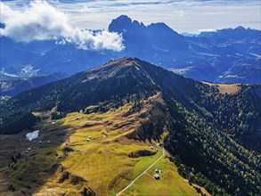 The Picberg, behind it the peaks of the Sassolungo Group, shrouded in mist, drone shot, Val