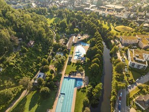 Outdoor pool complex with large swimming pools and surrounding green areas, embedded in a park