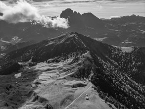 The Picberg, in the background the peaks of the Sassolungo group, shrouded in fog, drone shot,