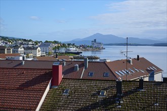 City view with red roofs of Molde, fjord landscape, sea, mountains in the background and blue,