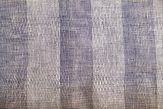 Fragment of smooth brown and violet linen tissue. Top view, flat lay, natural textile background