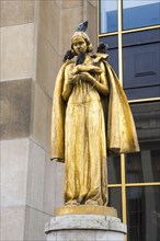 Golden statue Les Oiseaux (a woman feeding pigeons) by Louis Brasseur, street pigeons (Columba