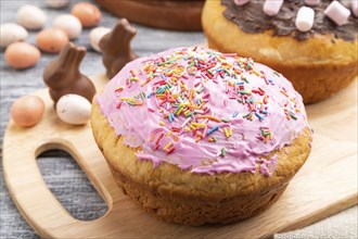 Homemade glazed and decorated easter pies with chocolate eggs and rabbits on a gray wooden