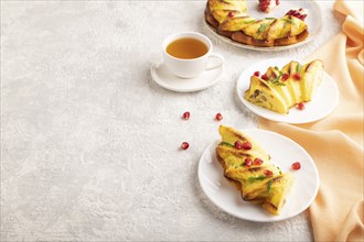 Cheesecake with cup of green tea on gray concrete background and orange linen textile. side view,