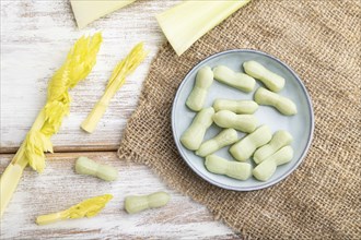 Jelly celery candies on white wooden background and linen textile. close up, top view, flat lay