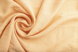 Fragment of orange linen tissue. Top view, flat lay, natural textile background and texture. wave