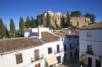 Defensive walls of the old city viewed over historic buildings near Puerta de Carlos V, Ronda,