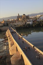 Roman bridge spanning river Rio Guadalquivir with Mezquita cathedral buildings, Cordoba, Spain,