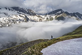 Mountaineer in front of mountain landscape with high fog in the valley, summit Hochfeiler and