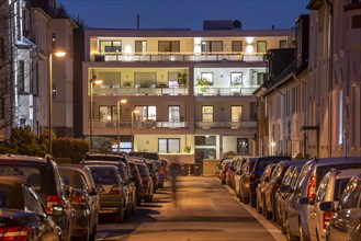 Residential street, many apartment buildings in a residential neighbourhood, evening, lantern