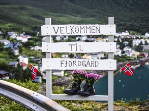 Fjordgard, village sign with flowers in shoes, welcome to Fjordgard, Senja, Troms, Norway, Europe