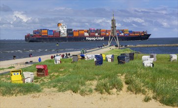 Beach promenade with landmark Kugelbake and container ship in the district of Döse, North Sea spa