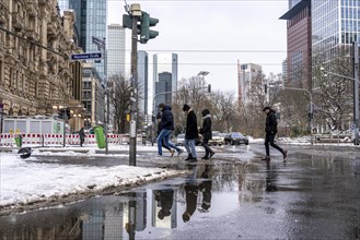 Winter in the city, Gallusanlage street, puddles, pools of water, melt water, pedestrians,