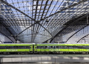 Central station, pillarless glass roof construction above the platforms, green train of the railway