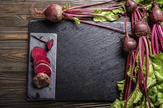 Top view at fresh organic beets with leaves on wooden rustic table close up view