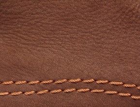 Brown leather suede with sewn seams background