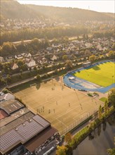 Overview of a football pitch in autumn atmosphere, surrounded by houses and hills, Nagold, Black