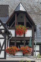 Balconies with lots of flowers in a typical half-timbered house with slate roof in Ernst, Landkreis