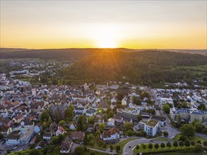 Town view at sunset with houses and natural surroundings, mountains in the background, Nagold,