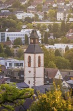 Municipal church tower in the afternoon, surrounded by various buildings and trees, Nagold, Black