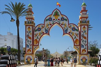 Decorative Tor tor with floral motifs and a crowd of people below, festive ambience, Feria de la