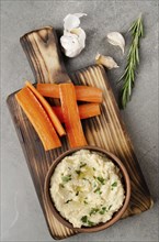 Flat lay view at vegetable Hummus dip dish topped with chickpeas and olive oil served with carrot