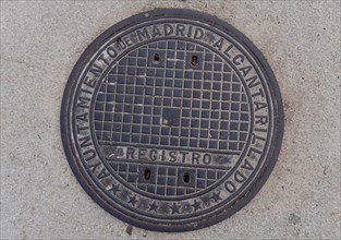 Madrid manhole cover on a busy street in Madrid, Spain, Europe