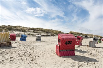 Beach chairs on a sandy beach with a blue sky, on the island of Langeoog