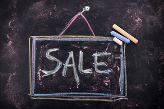 Graphic representation with chalk on blackboard the word sale