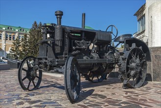 Old black tractor to plow a field (made in start of 20 century)