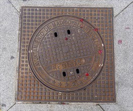 Madrid manhole cover on a busy street in Madrid, Spain, Europe