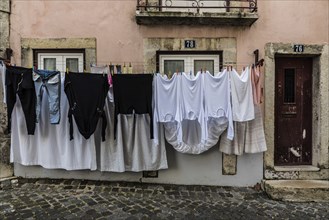 Lisbon, Portugal, 12 28 2018: Laundry hanging in the typical old streets with colorful houses in