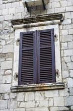 Wooden window with louvers in old house in the Kotor, Montenegro, Europe