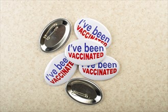 Vaccination campaign button pins on light tabletop flat lay view