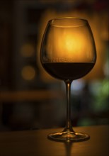 Red wine glass in cozy dark interior