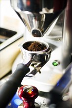 Classic coffee bean grinder detail with ground espresso portion