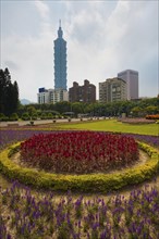 A colorful bed of flowers in the foreground of the Taipei 101 building in downtown Taipei, Taiwan,