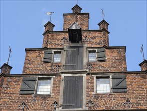 Gable of a historic building with several windows and shutters made of red brick, Bremen, Germany,