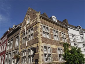 Historic brick houses in a city under a clear blue sky, maastricht. netherlands