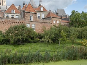 Historic wall and buildings surrounded by a lush garden and lots of greenery, zutphen, Netherlands