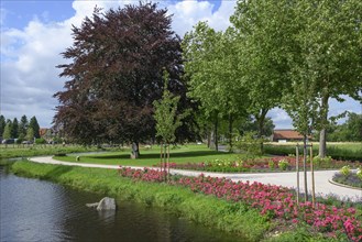 Idyllic park with a path along a pond, lined with flowers and trees, Raesfeld, North