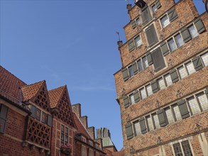 Two historic buildings with red brick facades and a clear blue sky in the background, Bremen,