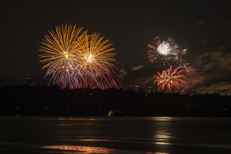 Fireworks over a lake with a reflection in the water