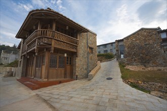 A traditional brick house with a typical curved wooden balcony in the village of Renai on Nangan