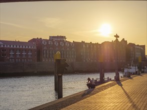 Sunset over a river with historic buildings on the banks, Bremen, Germany, Europe