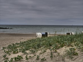 Coastal landscape with beach chairs on the beach, waves and cloudy sky, ahrenshoop, zingst, Baltic