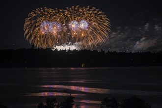 Fireworks over a lake with a reflection in the water