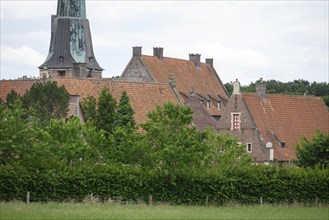 Close-up of a historic village with brick houses, church tower and dense vegetation, Raesfeld,