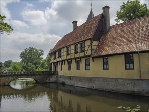 A picturesque historic half-timbered building reflected in the water of a river, Steinfurt, North